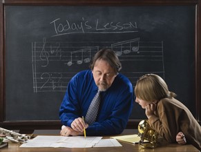 Music teacher and student in front of blackboard. Date : 2008