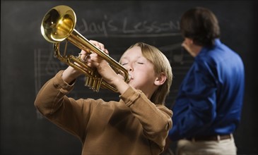 Boy playing trumpet in classroom. Date : 2008
