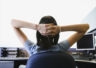 Businesswoman with hands behind head. Date : 2008