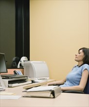 Businesswoman sitting at desk. Date : 2008