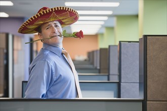 Businessman wearing sombrero and holding rose in teeth. Date : 2008