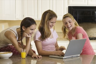 Teenaged girls looking at laptop. Date : 2008