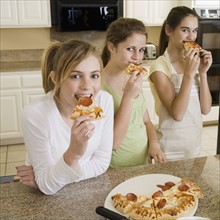 Teenaged girls eating pizza. Date : 2008