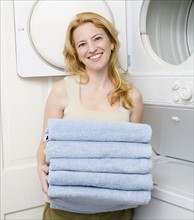 Woman holding folded towels. Date : 2008