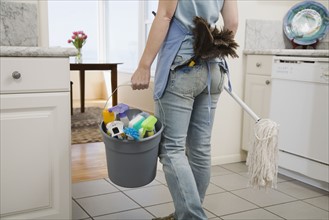 Woman holding mop and cleaning supplies. Date : 2008