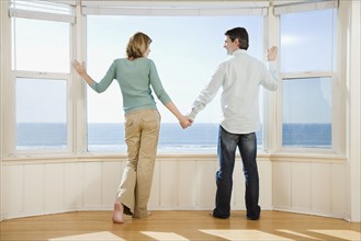 Couple holding hands next to window. Date : 2008