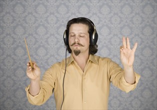 Man listening to headphones and conducting. Date : 2008