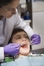 Female dentist examining patient. Date : 2008