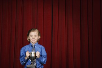 Boy holding trophy on stage. Date : 2008