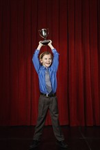 Boy holding trophy on stage. Date : 2008