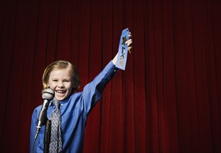 Boy holding first place ribbon on stage. Date : 2008
