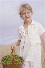 Girl holding basket of green beans. Date : 2008