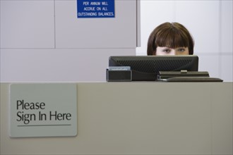 Receptionist sitting behind counter. Date : 2008