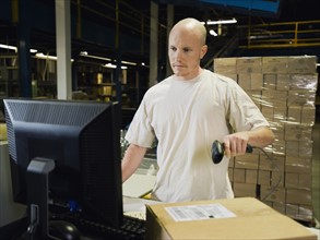 Warehouse worker scanning package. Date : 2008