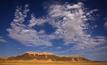 Clouds in blue sky over mountain, Namib Desert, Namibia, Africa. Date : 2008