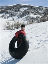 Boy carrying tube in snow. Date : 2008