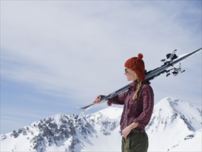 Woman holding skis on shoulder. Date : 2008