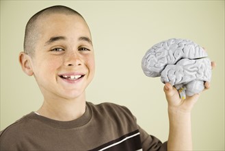 Boy holding human brain model. Date : 2008