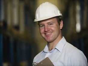 Man wearing hard hat and holding clipboard. Date : 2008
