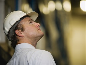 Man wearing hard hat and looking up. Date : 2008