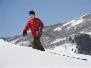 Boy pulling sled in snow. Date : 2008
