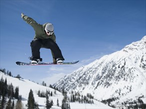 Man on snowboard in air, Wasatch Mountains, Utah, United States. Date : 2008