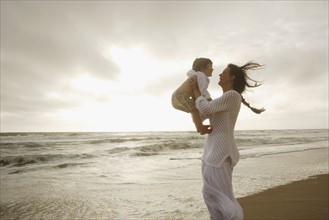 Mother holding son at beach. Date : 2008