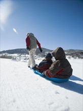 Father pulling children on sled. Date : 2008