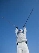 Woman holding ski poles over head. Date : 2008