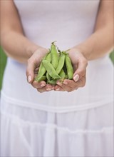 Woman holding fresh peas.