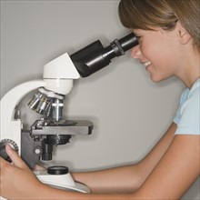 Girl using microscope.