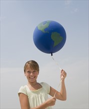 Girl holding globe balloon.