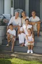 Multi-generational family sitting on front stoop.