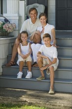 Family sitting on front stoop.