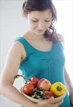 Teenage girl carrying bowl of fresh fruit and vegetables. Date : 2008