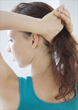 Teenage girl pulling hair into ponytail. Date : 2008