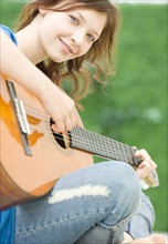 Teenage girl playing guitar. Date : 2008
