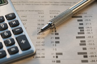 Close up of pen, calculator and financial pages. Date : 2008
