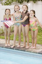 Girls waving American flag poolside. Date : 2008