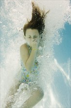 Girl plugging nose underwater. Date : 2008