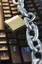Close up of lock and chain on computer keyboard. Date : 2008