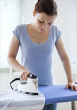 Teenage girl ironing clothes. Date : 2008