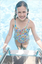 Girl standing on swimming pool ladder. Date : 2008
