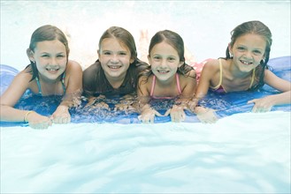 Girls resting on inflatable raft in swimming pool. Date : 2008