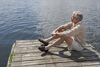 Senior man sitting on dock.