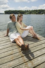 Couple sitting on dock.