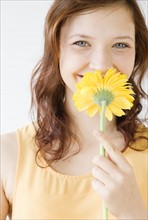 Teenage girl smelling flower. Date : 2008