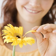 Teenage girl plucking flower petal. Date : 2008