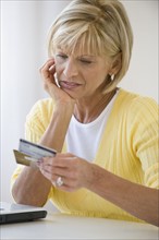 Woman looking at credit cards with concern.