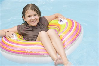 Girl floating in inflatable ring in swimming pool. Date : 2008